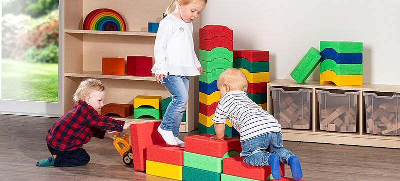 Kinder spielen mit farbigen Spielzeugblöcken