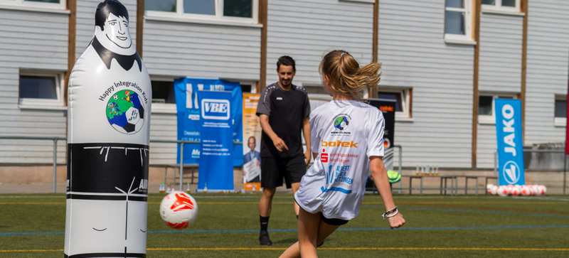 Kinder spielen Fußball auf einem Fußballplatz. 