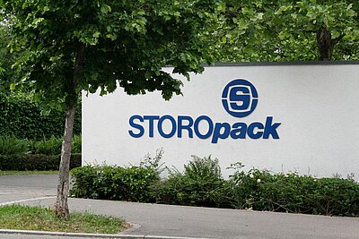 Eine weiße Mauer mit blauem Storopack Logo