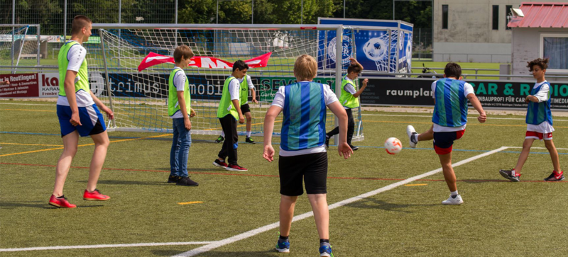 Kinder spielen Fußball auf einem Fußballplatz. 